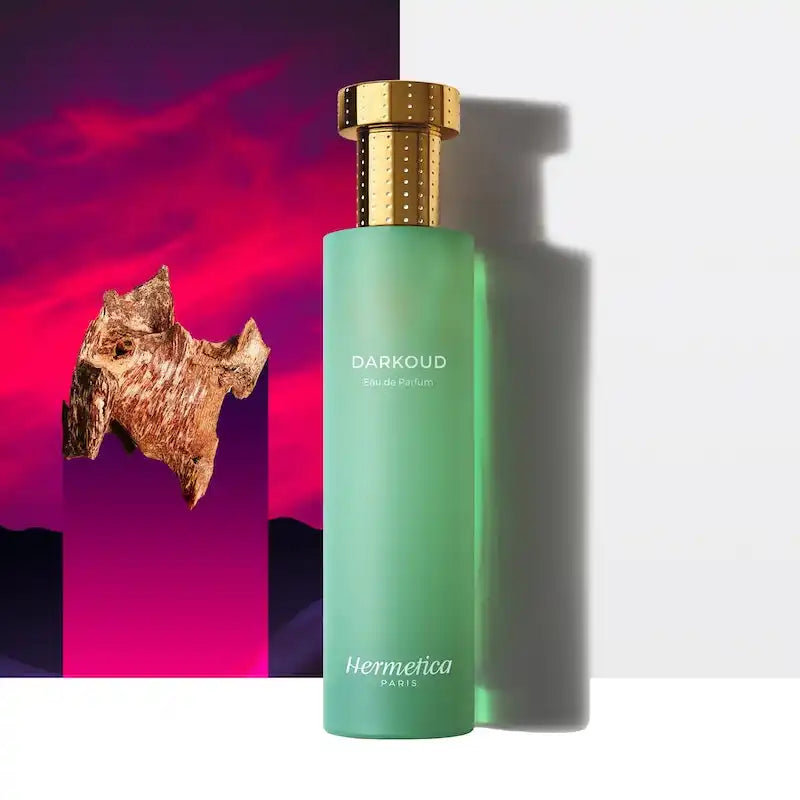 Mint green perfume bottle with a gold cap labeled ’Darkoud’ by Hermetica.
